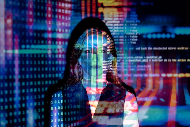 Computer code projected over a woman.
