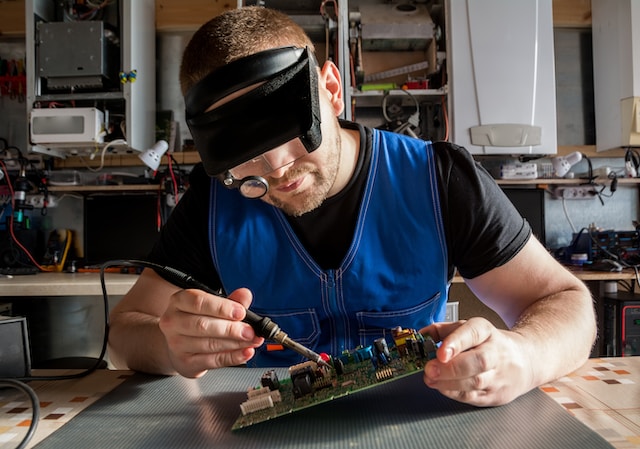 An electrician working on a circuit board