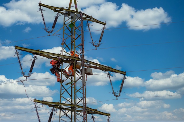 Two electrician working atop a transmission tower