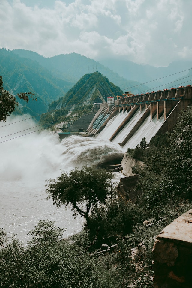 Water dam on a mountainside releasing powerful surges of water into the river below