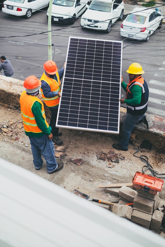 A group of men prepping a solar panel for installation