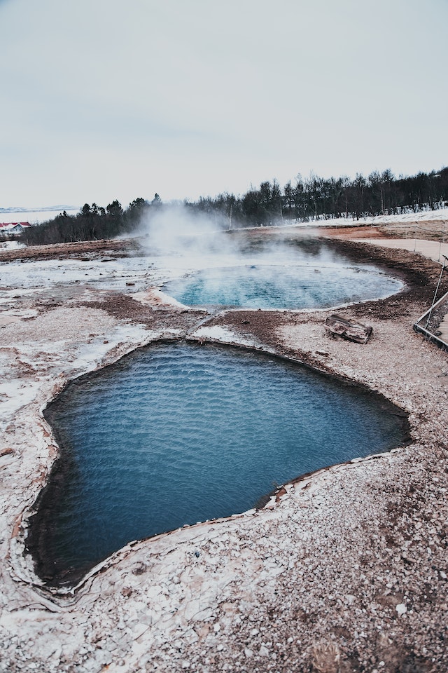 Steam rises from a hot spring, indicating volcanic activity