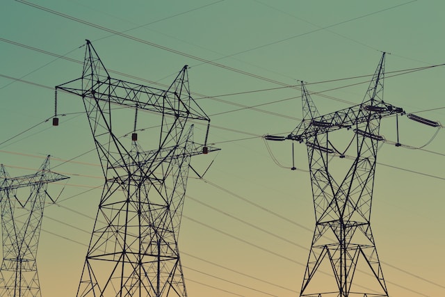 Power lines crisscrossing a few electric transmission towers