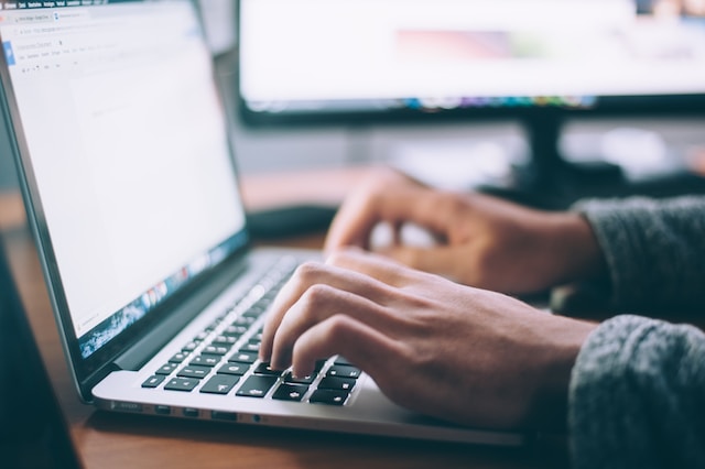 Closeup of hands typing on a laptop keyboard