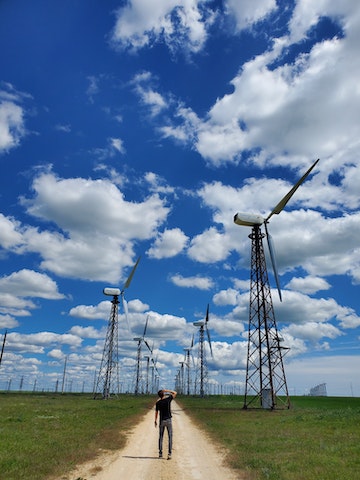 Man standing on a field of wind turbines