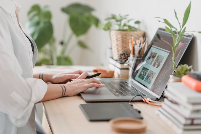 Person retouching images on a laptop