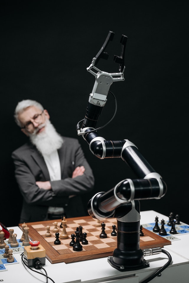 Man playing chess with a robotic arm