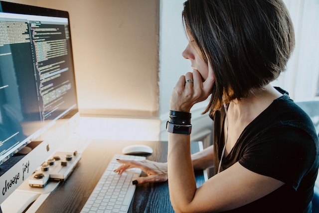 Woman with hands on a white keyboard looking at her screen