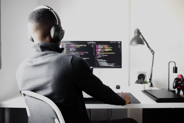 Person wearing headphones working on his computer