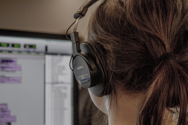 Person with headphones on and a computer in front of them